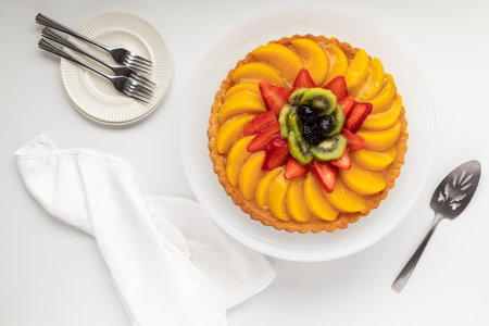 Top down view of a German fruit flan including peaches, strawberries and kiwi.の写真素材
