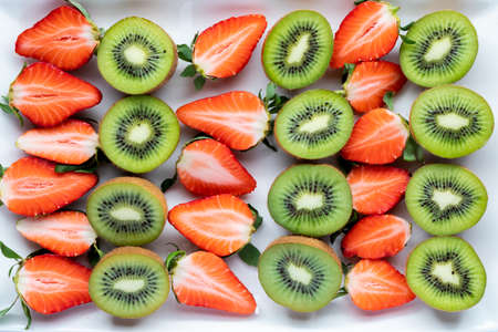 Rows of cut kiwis and strawberries. Complimentary fruit flavoursの写真素材