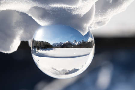 View of a scenic snow peaked mountain range in a lens ball on a sunny day.の写真素材
