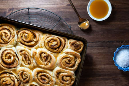 Top down view of cinnamon buns in a pan with caramel sauce and course salt.の写真素材