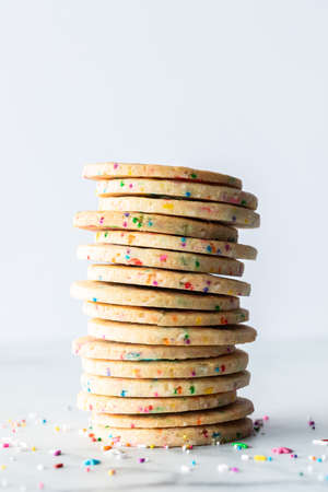 Close up of a stack of sprinkle sugar cookies against a light background.の写真素材