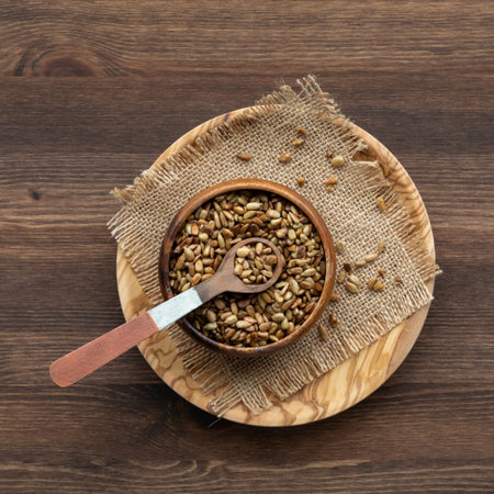 A wooden bowl filled with toasted sunflower seeds ready for snacking.の写真素材
