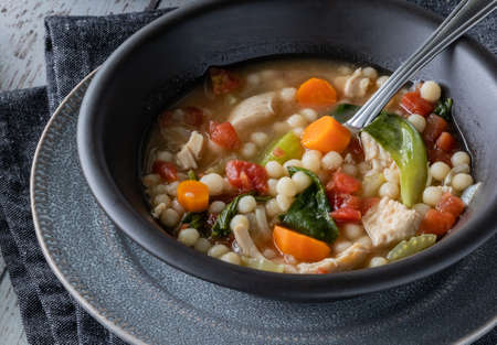 Close up of a bowl of chicken and vegetable with couscous soup, ready for eating.の写真素材