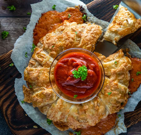 Top down view of a homemade puff pastry pizza ring served with pizza sauce.の写真素材