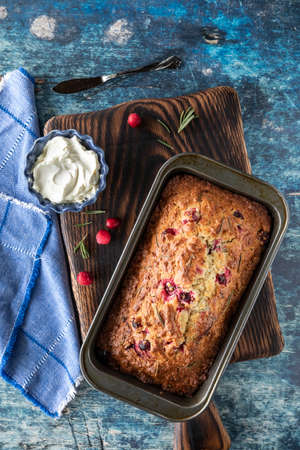 Top down view of a cranberry and rosemary loaf fresh out of the oven cooling on a wooden board.の写真素材