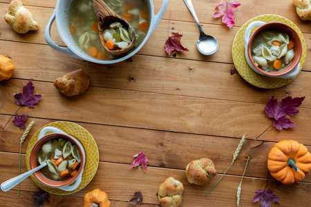 Bowls of homemade turkey soup for Thanksgiving with copy space in the middle.の写真素材