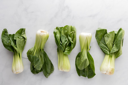 Top down view of fresh bok choy clusters against a marble background.の写真素材