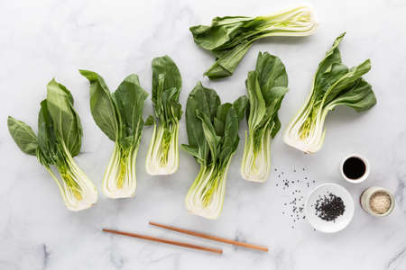 Bok choy clusters with sesame seeds, soy sauce and chopsticks, taken from above.の写真素材