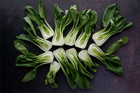 Top down view of an arrangement of bok choy clusters against a dark background.の写真素材