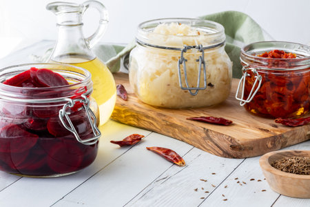 Jars of fresh pickled vegetables against a light background.