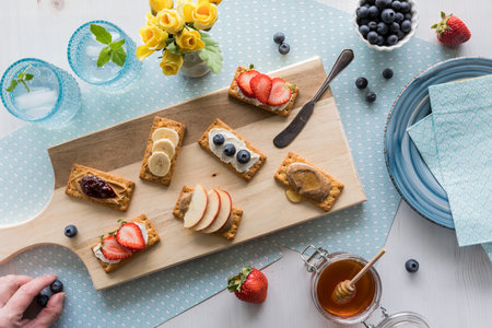 Breakfast crackers with various toppings of fresh fruit and cream cheese spread.