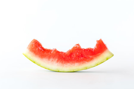 Close up of a mostly eaten watermelon slice isolated against a white background.の写真素材