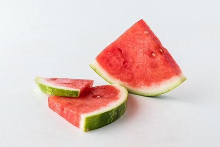Close up of slices of fresh watermelon against a white background.の写真素材