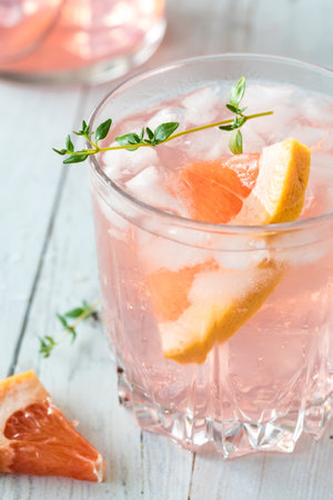 Close up of a grapefruit spritzer garnished with a grapefruit slice and thyme.の写真素材