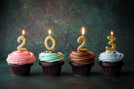 Cupcakes with golden lit number candles for the New Year 2023.の写真素材