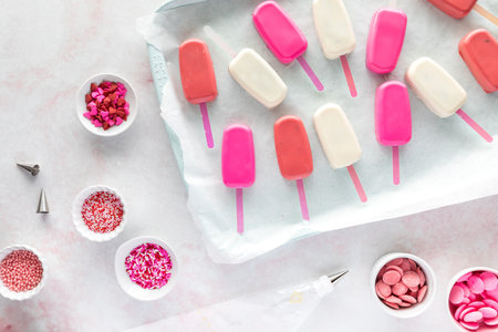 undecorated cake pops with various sprinkles and candy melts all around.の写真素材