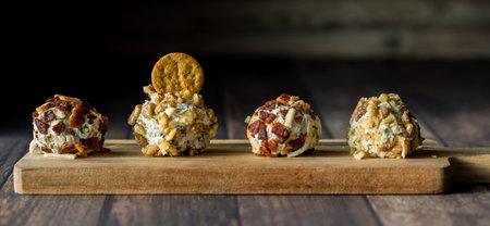 A row of dill pickle fat bombs for spreading on crackers, on a wooden board.の写真素材