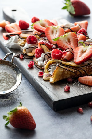 A platter of keto crepes filled with coconut whip cream and topped with berries.の写真素材