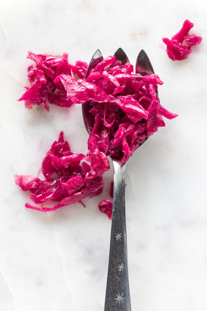 Pickled beet and red cabbage sauerkraut on a serving fork.の写真素材