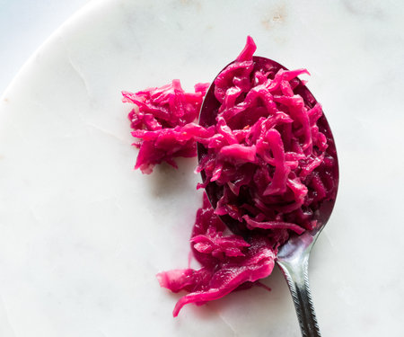 Bright pink beet and cabbage sauerkraut on a large spoon.の写真素材