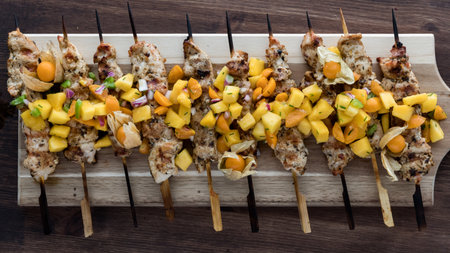 Grilled seasoned chicken skewers topped with golden berry salsa.の写真素材