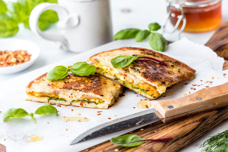 Egg and cheese naan bread breakfast sandwiches topped with honey and basil.の写真素材
