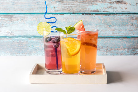 Three refreshing seltzers with various fruit garnishments.の写真素材