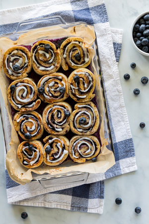 Above view of a dozen freshly made blueberry cinnamon buns, hot out of the oven.の写真素材