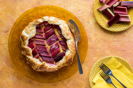 Rhubarb and custard galette on a golden glass plate, ready for serving.の写真素材
