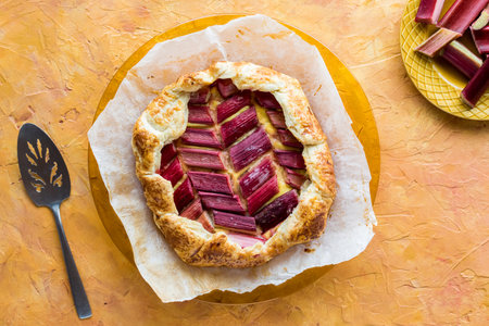 A rhubarb and custard galette on a parchment lined plate, ready for serving.の写真素材