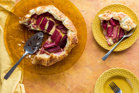 A freshly made rhubarb galette with a slice to the side.の写真素材