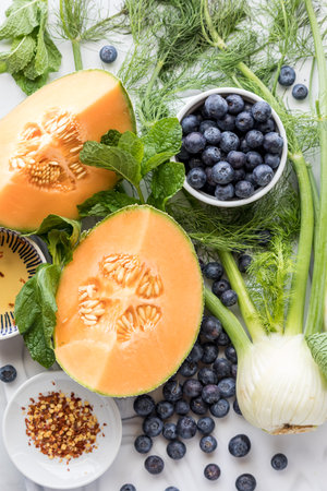 Fresh Ingredients for making a fennel, melon and blueberry salad.の写真素材