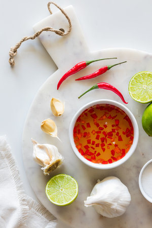 Above view of a bowl of nuoc mam dressing with ingredients all around.の写真素材