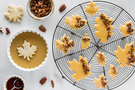 Freshly glazed maple pecan shortbread cookies on a cooling rack.の写真素材