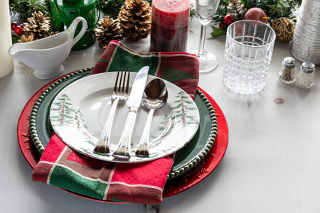 A view of a fancy holiday table setting with decorations.