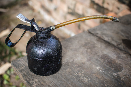 Black Old oil can on old wooden desk