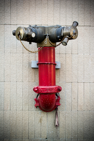 red fire hose on the concrete wallの写真素材
