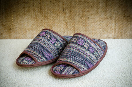 Northern Thai fabrics slippers on cream blanketの写真素材