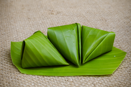 Thai style dessert wraped with banana leavesの写真素材