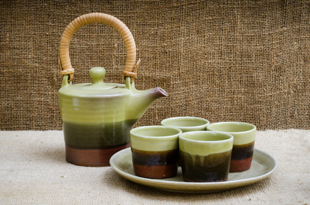 Green ceramic tea set on brownish sackの写真素材