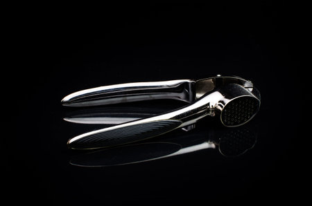 Stainless steel Garlic press on black backgroundの写真素材