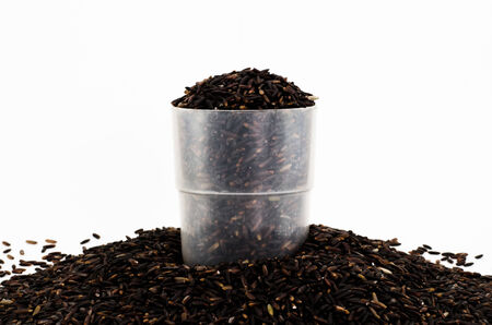 Organic black rice in plastic cup on white backgroundの写真素材