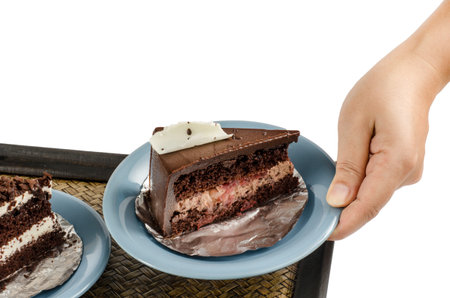 Image of chocolate cake in ceramic dish with hand on white backgroundの写真素材