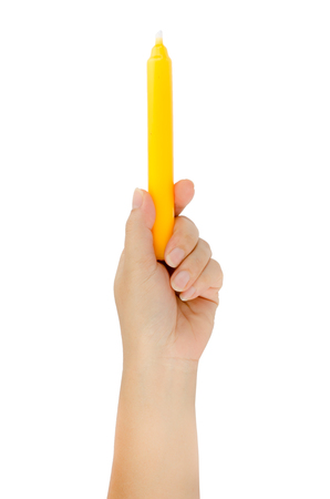 Human hand holding yellow candle isolate on white backgroundの写真素材