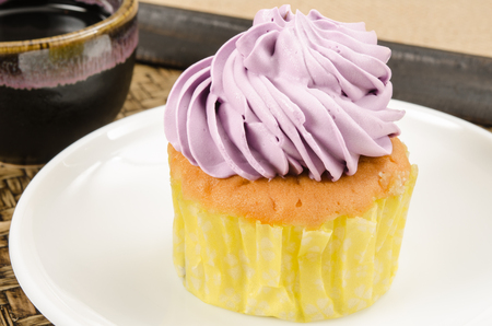 Image of cup cake in white dish on bamboo woven trayの写真素材