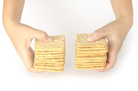 Image of hand with saltine crackers on white backgroundの写真素材