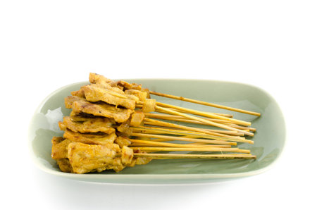 Grilled Pork Satay in green ceramic dish on white backgroundの写真素材