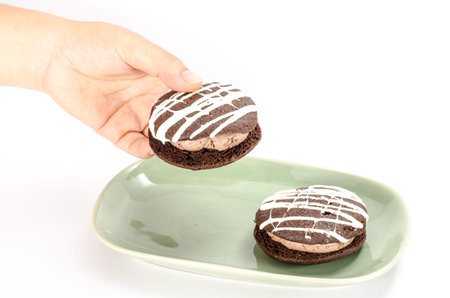 Image of chocolate cookie cake in green ceramic dish holding by handの写真素材
