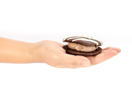Image of chocolate cookie cake in human hand on white backgroundの写真素材