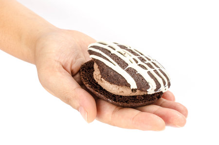 Image of chocolate cookie cake in human hand on white backgroundの写真素材